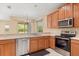 Kitchen showcasing stainless steel appliances, wood cabinets, and countertops with backyard view at 9469 Edenshire Cir, Orlando, FL 32836