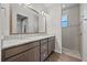 Bathroom featuring dual sinks, granite countertops, and a tiled shower with a window at 951 Cutke Rd, St Cloud, FL 34771