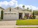 Charming single-story home featuring a brick driveway, manicured lawn, and delightful landscaping at 951 Cutke Rd, St Cloud, FL 34771