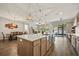 A kitchen island features pendant lights and overlooks dining and living areas with tile flooring at 951 Cutke Rd, St Cloud, FL 34771