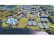 Aerial view of a community pool, tennis courts, and clubhouse near a scenic lake and lush landscaping at 1210 Pallister Ln, Lake Mary, FL 32746