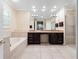 Bathroom featuring a tub, shower, tiled floors, dual sinks, granite counters and dark wood cabinets at 1210 Pallister Ln, Lake Mary, FL 32746