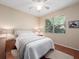 Cozy bedroom with hardwood floors, ceiling fan, a large window overlooking the backyard and an off-white color scheme at 1210 Pallister Ln, Lake Mary, FL 32746
