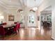 Spacious dining room features hardwood floors, elegant lighting, and a large round table with red velvet chairs at 1210 Pallister Ln, Lake Mary, FL 32746
