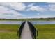 Scenic view of a dock extending onto a calm lake under a blue sky with fluffy clouds at 1210 Pallister Ln, Lake Mary, FL 32746