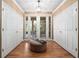 Hallway with french doors to the sitting room, flanked by two large closets and a central sitting ottoman at 1210 Pallister Ln, Lake Mary, FL 32746