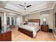 Large primary bedroom featuring trey ceilings, wood floors, a ceiling fan and french doors to the sitting area at 1210 Pallister Ln, Lake Mary, FL 32746