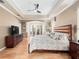 Large primary bedroom with trey ceilings, wood floors, a ceiling fan and a cozy sitting area with french doors at 1210 Pallister Ln, Lake Mary, FL 32746