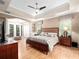 This primary bedroom features a ceiling fan, wood floors, trey ceilings and a sitting area at 1210 Pallister Ln, Lake Mary, FL 32746