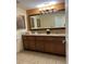 Bathroom with double sink vanity, granite countertops, and framed mirror at 12539 Floridays Resort Dr 411 # 411D, Orlando, FL 32821