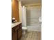 Well-lit bathroom features a vanity with granite counters and a shower-tub combo with white curtain at 12539 Floridays Resort Dr 411 # 411D, Orlando, FL 32821