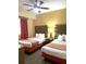 Bright bedroom features two beds, a ceiling fan, and patterned curtains for a comfortable stay at 12539 Floridays Resort Dr 411 # 411D, Orlando, FL 32821
