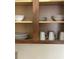 Close up of kitchen cabinet with plates, bowls, and mugs neatly arranged on shelves at 12539 Floridays Resort Dr 411 # 411D, Orlando, FL 32821
