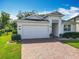 Home featuring a well-manicured lawn, brick driveway, and a 2-car garage at 3631 Arbordale Loop, Sanford, FL 32771