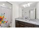 Bathroom with a double sink vanity, granite countertops, and decorative shower curtain at 4582 Terrasonesta Dr, Davenport, FL 33837