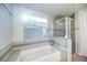 Bright bathroom featuring a bathtub, shower, and tiled walls at 8812 Kensington Ct, Kissimmee, FL 34747