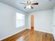 Bright bedroom featuring hardwood floors, ceiling fan, and closet at 8812 Kensington Ct, Kissimmee, FL 34747