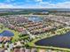 Panoramic aerial view showcasing a Primary-planned community with lakes, lush landscaping and tile roofs at 10254 Beechwood Ln, Orlando, FL 32832