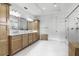 Spacious bathroom with wood cabinets, double vanity, white countertops, and glass-enclosed shower at 10254 Beechwood Ln, Orlando, FL 32832
