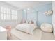 Bright bedroom with a four-poster bed, large window, and soft blue accent wall at 10254 Beechwood Ln, Orlando, FL 32832