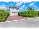 Charming two-story home with a brick driveway and a two-car garage, surrounded by lush green hedges at 10254 Beechwood Ln, Orlando, FL 32832