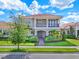 Charming two-story home with a balcony, red tile roof, and beautifully landscaped front yard at 10254 Beechwood Ln, Orlando, FL 32832