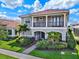 Two-story home featuring a red tile roof, balcony, lush landscaping, and green lawn at 10254 Beechwood Ln, Orlando, FL 32832