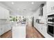 Bright kitchen features quartz counters, stainless appliances, pendant lights, and wood floors at 10254 Beechwood Ln, Orlando, FL 32832