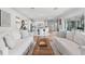 Open-concept living room with white sofas, hardwood floors, and seamless flow to the kitchen and dining area at 10254 Beechwood Ln, Orlando, FL 32832