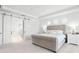 Bright bedroom with sliding doors to bathroom, tufted headboard and white furniture at 10254 Beechwood Ln, Orlando, FL 32832
