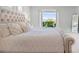 Close-up of a main bedroom bed with upholstered headboard, decorative pillows, and a balcony view at 10254 Beechwood Ln, Orlando, FL 32832