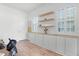 Home office with custom built-ins, floating shelves, and shuttered windows creating a professional workspace at 10254 Beechwood Ln, Orlando, FL 32832