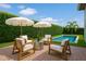 Inviting patio with modern outdoor furniture, umbrellas, and a view of the sparkling pool at 10254 Beechwood Ln, Orlando, FL 32832