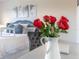 Bedroom view with red roses, a comfy bed and a grey velvet chair at 17407 Hidden Forest Dr, Clermont, FL 34714
