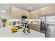 Modern kitchen with stainless steel appliances, sleek countertops, and light wood cabinets at 17407 Hidden Forest Dr, Clermont, FL 34714