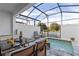 Relaxing screened-in pool area with comfortable seating and a dining table, ideal for enjoying meals by the water at 17407 Hidden Forest Dr, Clermont, FL 34714