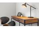 Close-up of a desk with a lamp and decor, highlighting a functional and stylish workspace at 17407 Hidden Forest Dr, Clermont, FL 34714