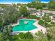 Aerial view of the pool area and a surrounding community with lounge chairs and umbrellas at 200 Maitland Ave # 87, Altamonte Springs, FL 32701
