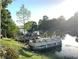 Waterfront view of two pontoon boats, lush foliage, and a serene waterfront area at 200 Maitland Ave # 87, Altamonte Springs, FL 32701