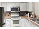 Compact kitchen features white cabinets, stainless steel appliances, and ample counter space at 2832 Risser Ave, Orlando, FL 32812