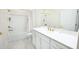Bright bathroom featuring white vanity, white tile flooring and a bathtub at 4012 Meandering Bay Dr, Apopka, FL 32712