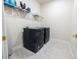 Modern laundry room equipped with sleek, dark appliances, a wire rack, and tiled flooring for easy maintenance at 4012 Meandering Bay Dr, Apopka, FL 32712