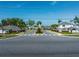 A street view into the neighborhood, with tropical landscaping and well maintained homes in the distance at 4012 Meandering Bay Dr, Apopka, FL 32712