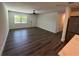 Open-concept living room featuring sleek hardwood floors and a ceiling fan for comfort at 545 Brooks Ct, Polk City, FL 33868