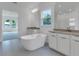Bright bathroom with a soaking tub, double vanity, and view of adjoining room at 10013 Brocksport Cir, Gotha, FL 34734