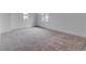 Bright bedroom featuring two windows providing natural light and plush carpeting at 10013 Brocksport Cir, Gotha, FL 34734
