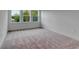 A bright bedroom featuring three large windows, white walls and trim, and neutral carpeting at 10013 Brocksport Cir, Gotha, FL 34734