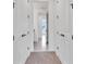 Hallway featuring white doors with bronze hardware leading to other rooms with carpeted floors at 10013 Brocksport Cir, Gotha, FL 34734