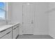 Well-lit laundry room with a utility sink, white cabinets, and a storage shelf at 10013 Brocksport Cir, Gotha, FL 34734