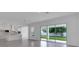 Open-concept living room featuring tile floors, large sliding glass doors, and seamless kitchen access at 10013 Brocksport Cir, Gotha, FL 34734